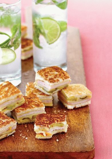 Foto von einem kubanischen Sandwich, gefüllt mit Schweinefilet und Schinken, mit Bananenchips und Mojito