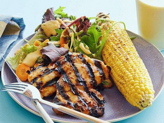 Foto von Hühnchen in Barbecue-Sauce mit Blattsalat, gegrilltem Mais und Smoothies