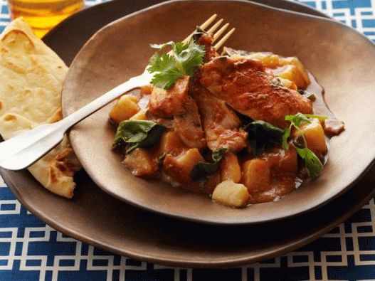 Foto von Huhn in Curry-Tomatensauce mit Kartoffeln und Spinat