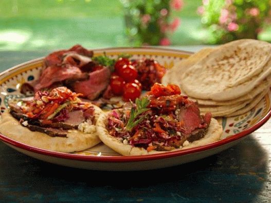 Foto von Pita mit Lammfleisch in Granatapfelglasur mit Minze am Spieß, gegrillten Tomaten und griechischem Krautsalat