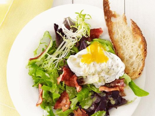 Fotosalat mit pochiertem Ei und Speck in einem Café