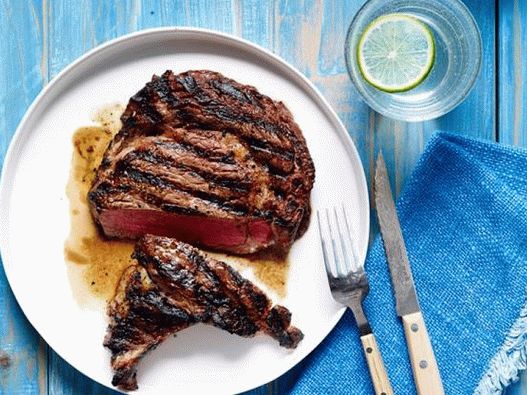 Foto von Striploin Steaks auf Holzkohle