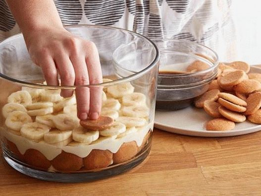 Lege abwechselnd die Schichten Pudding und Bananen auf die Kekse.