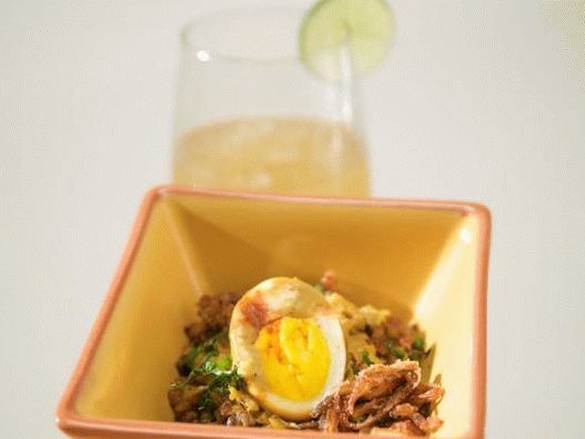 Foto von Eiern in Currysauce mit Reisgarnitur und Zwiebelringen